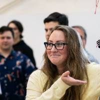 A student shows off her boat
